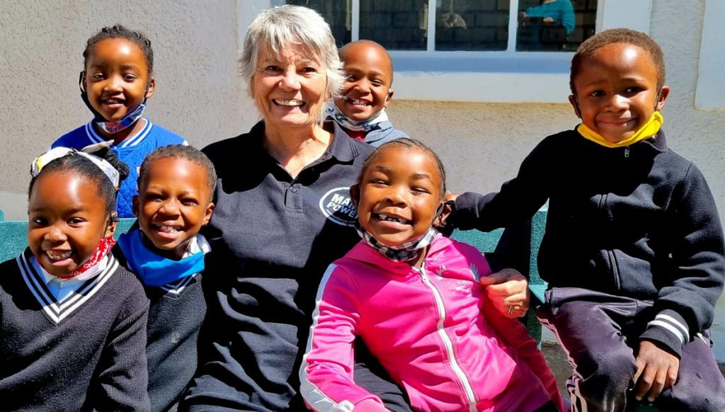 Een portret van MAMA Lesley met een aantal kinderen die gesteund worden door het project Hantam.