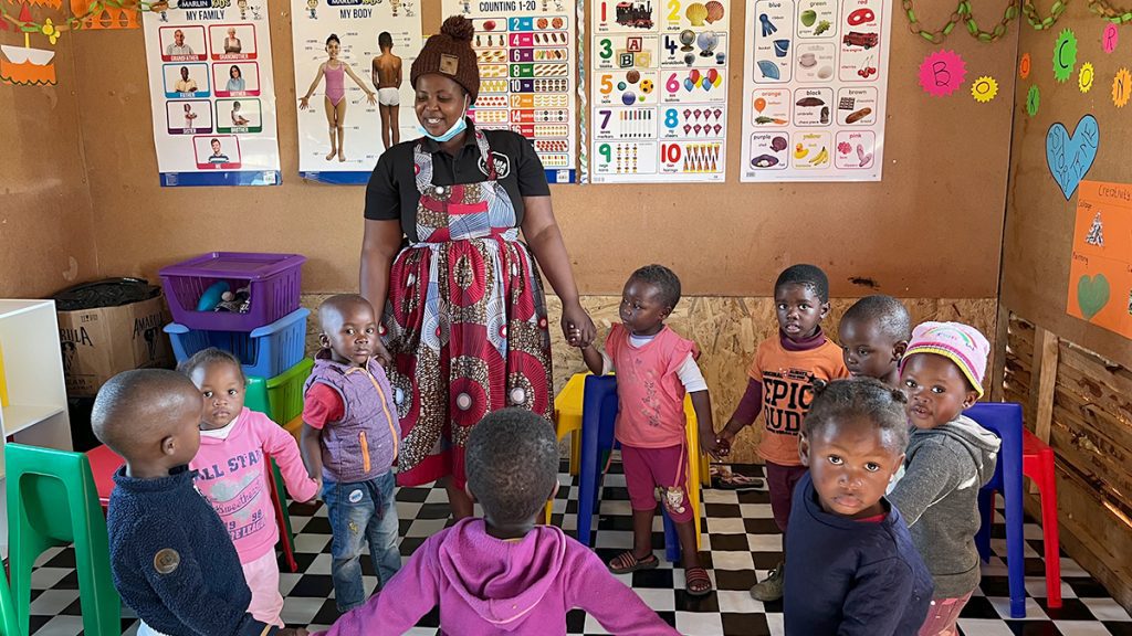 MAMA Yonele loopt in een kringetje samen met de kinderen van Qulashe